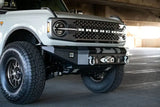 DV8 Offroad 2021+ Ford Bronco front bumper, winch-capable, with optional bull bar and aux light opening, shown on white Ford Bronco.
