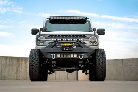 Ford Bronco 2021 with a DV8 Offroad Modular Front Bumper, Winch Capable, and Auxiliary Light Mounts in an outdoor setting.