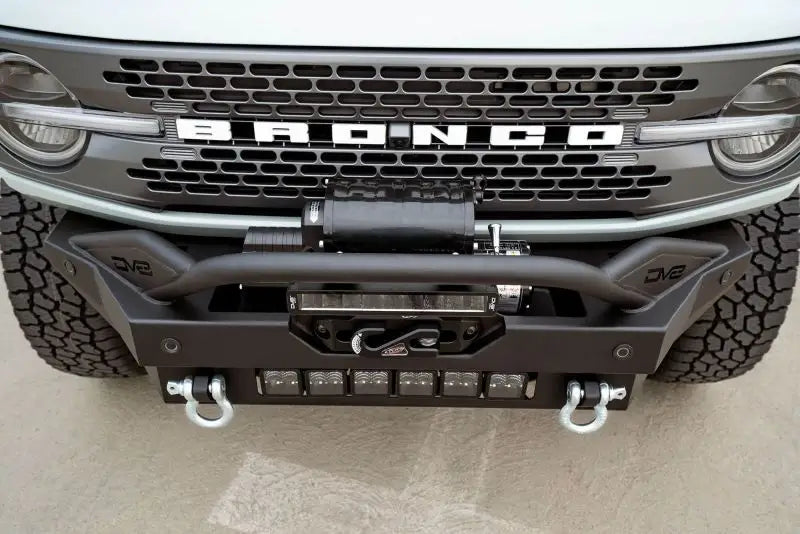 DV8 Offroad 2021+ Ford Bronco Modular Front Bumper Winch Capable with Auxiliary Light Mounts, featuring a bull bar, 13-inch light bar, and recovery mounts.