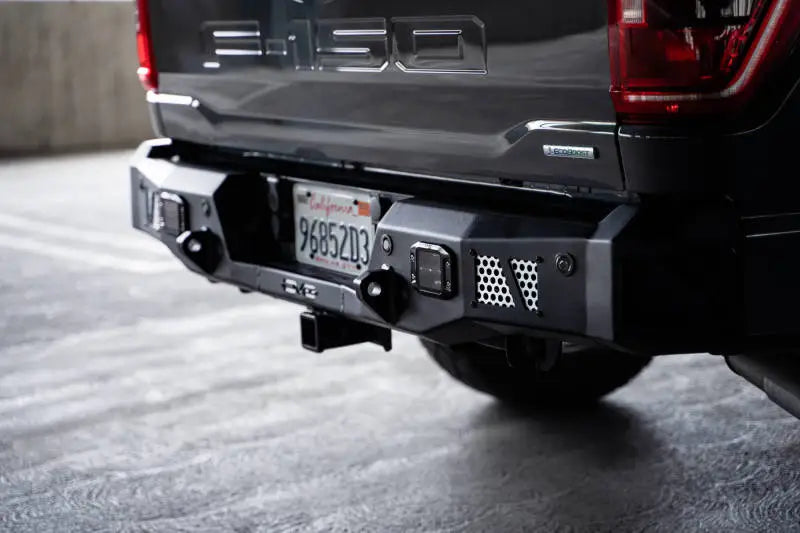 DV8 Offroad MTO Series Rear Bumper on 2021-2023 Ford F-150, featuring steel construction, utility steps, and light pod mounts.