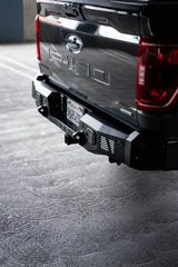 DV8 Offroad MTO Series Rear Bumper on a 2021-2023 Ford F-150, featuring gusseted steel construction, utility steps, and clevis mounts.