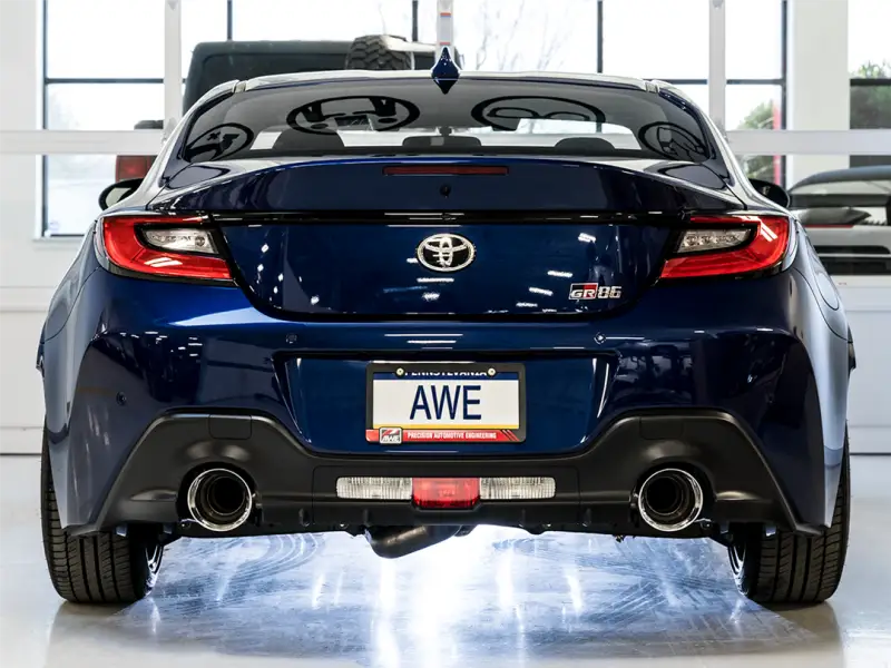 Rear view of a blue sports car featuring AWE's Touring Edition Cat-Back Exhaust System Kit, showcasing dual chrome silver tips and rear exit exhaust.