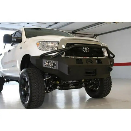 FF21-K5060-1 Fab Fours Elite Series Front Bumper on lifted white truck in garage, showcasing rugged design and high-quality construction.