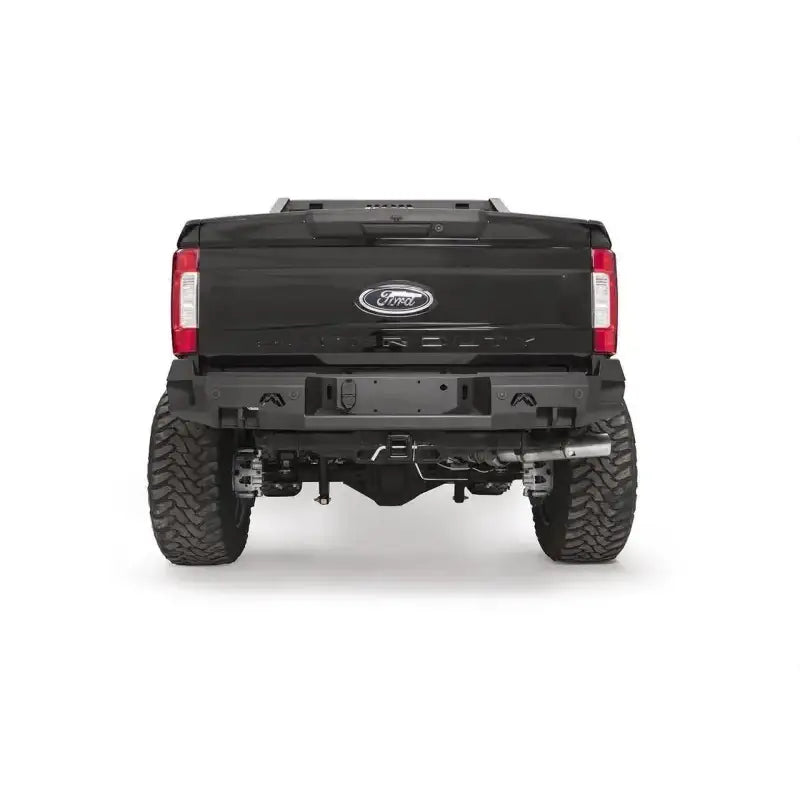 FS17-W4151-1 Fab Fours rear sensor bumper on a Ford F250/F350, showcasing rugged design, integrated sensor openings, and enhanced off-road durability.