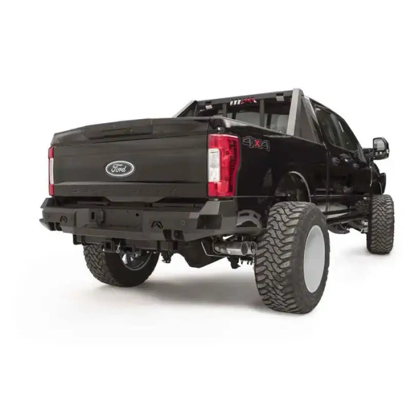 FS17-W4151-1 Fab Fours rear sensor bumper installed on a lifted Ford Super Duty F250-F350, featuring a rugged design with integrated sensor openings and robust construction for off-road protection and enhanced style.