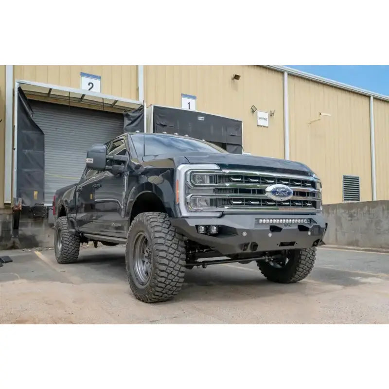 FS23-X5951-1 Fab Fours Matrix Front Bumper on a black Ford truck, showcasing its rugged design and superior front-end protection in a parking lot.
