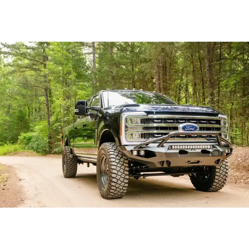 FS23-X5952-1 Fab Fours Matrix Front on a rugged off-road truck in a forest setting, showcasing high-quality construction and aggressive styling for maximum protection, Bumpers, Grilles & Guards, AVADA - Best Sellers, Must Haves
