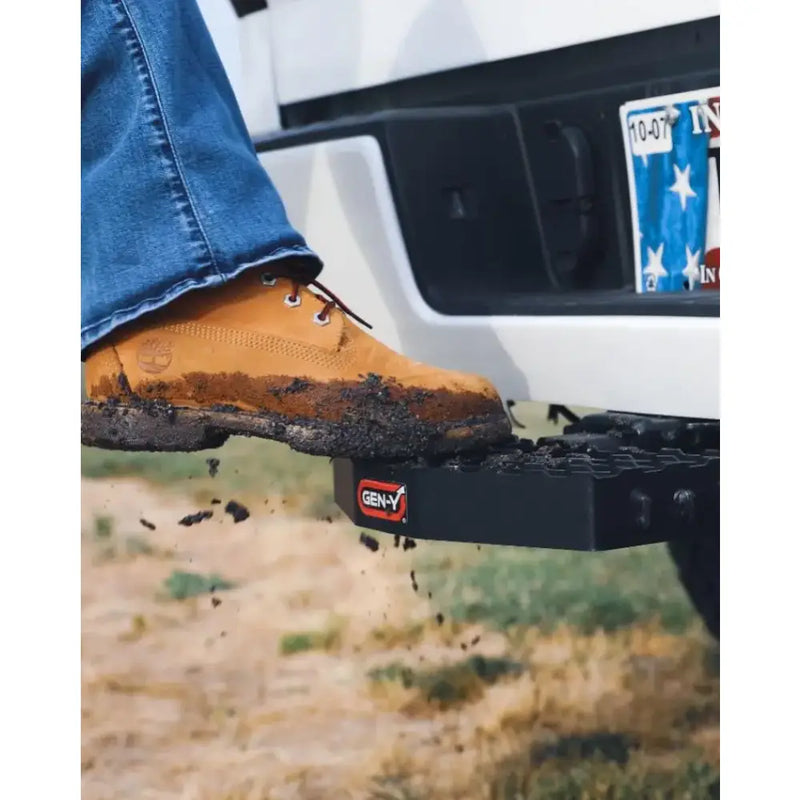 Mud-covered boot stepping on GH-030 Gen-Y Hitch with 2' shank, heavy-duty design, and serrated surface for secure towing connection.