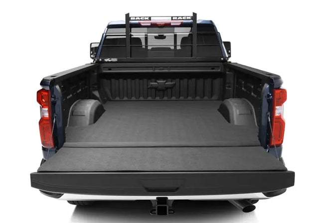 Black powder-coated steel headache rack frame by BACKRACK™, fits truck with or without tonneau cover, installed on blue truck bed.