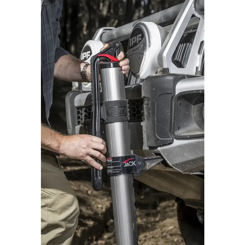Person using ARB hydraulic jack to lift a vehicle off-road.