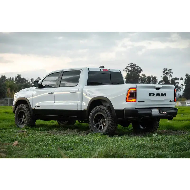ICON Vehicle Dynamics 2019+ Ram 1500 with .75-2.5in Stage 1 Suspension System, shown lifted with aggressive tires in grassy outdoor setting.