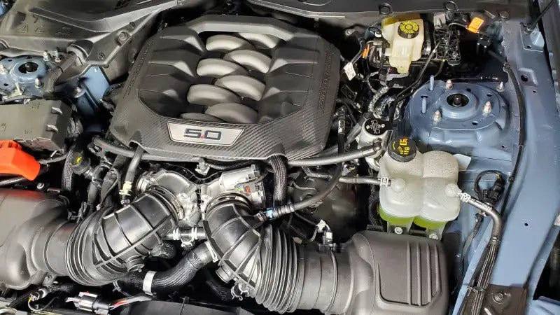 Car engine compartment with J&L 2024 Ford Mustang 5.0L oil separator close-up