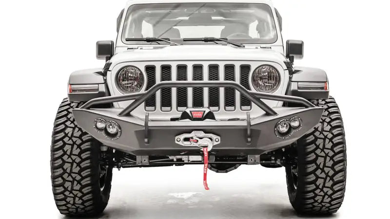 Front view of a Jeep equipped with the JL18-B4652-1 Fab Fours Lifestyle Winch Bumper with Guard, showcasing rugged off-road appearance and integrated winch.