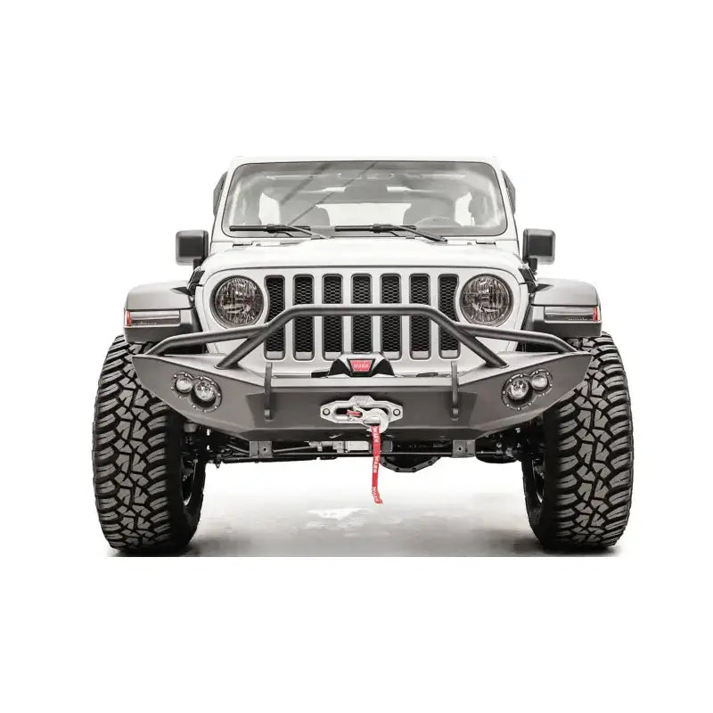 Front view of a Jeep equipped with the JL18-B4652-1 Fab Fours Lifestyle Winch Bumper with Guard, showcasing rugged off-road appearance and integrated winch.