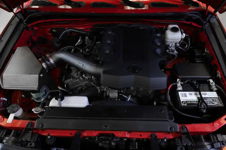 Red engine bay with black engine in a Toyota 4Runner performance air intake system