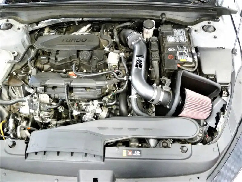 K&N 21-22 Kia K5 L4-1.6L Typhoon Air Intake installed in car engine bay, featuring mandrel-bent aluminum intake tube and washable High-Flow Air Filter. Enhanced performance for automotive, off-road, and racing applications.