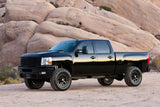 Black pickup truck equipped with K1065DL Fabtech Leveling Kit Suspension, enhancing stance and ground clearance, parked in a rocky desert landscape.