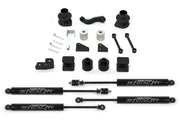 K4037M Fabtech Lift Kit Suspension components laid out, including shocks, mounts, and hardware for increased ground clearance and off-road performance.