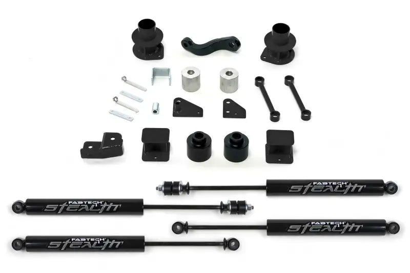 K4037M Fabtech Lift Kit Suspension components laid out, including shocks, mounts, and hardware for increased ground clearance and off-road performance.