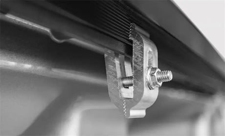 Metal clamp with threaded bolt and nut for securing to a ribbed rail on Lomax Stance Hard Cover