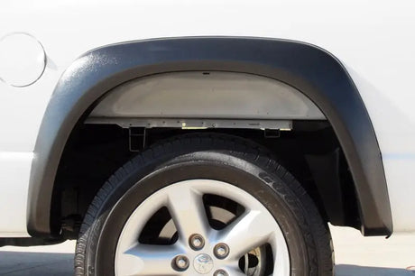 Truck wheel well with tire featuring Lund ex-extrawide style fender flares for Dodge Ram