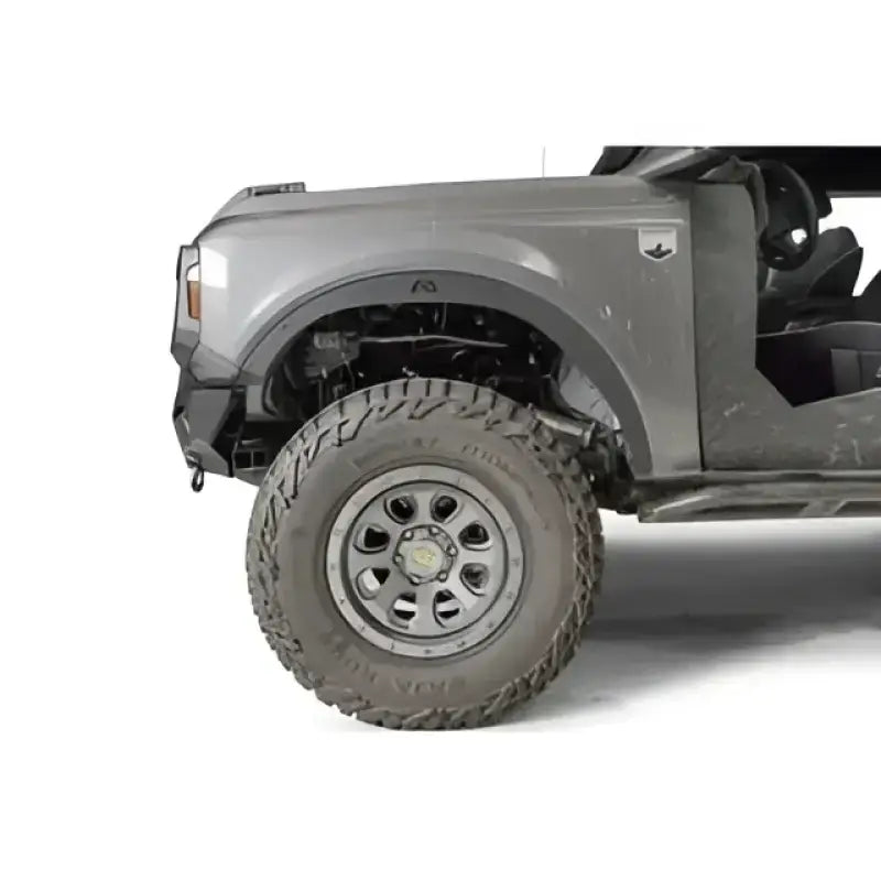Fab Fours 21-22 Ford Bronco accessory relocation bracket installed on a gray Ford Bronco's front tire area, showcasing durable construction and precise fit.