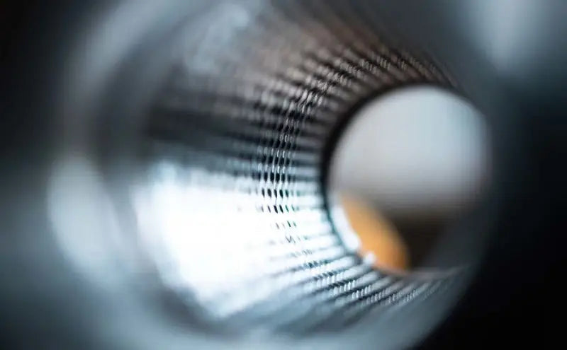 Close-up view inside the MagnaFlow Muffler Mag SS 14X4X9 2.5 D/D, showcasing its perforated stainless steel core and mesh, engineered for optimal exhaust sound and performance.