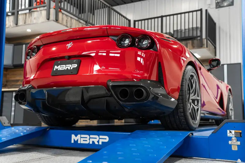 Red sports car on lift showcasing ferrari 812sf with resonator delete exhaust upgrade