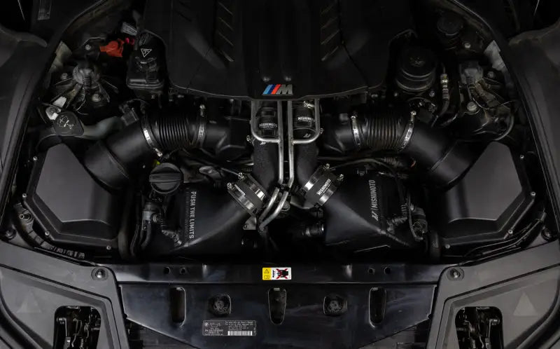 Car engine compartment with Mishimoto BMW F10 M5 intercooler kit in wrinkle black