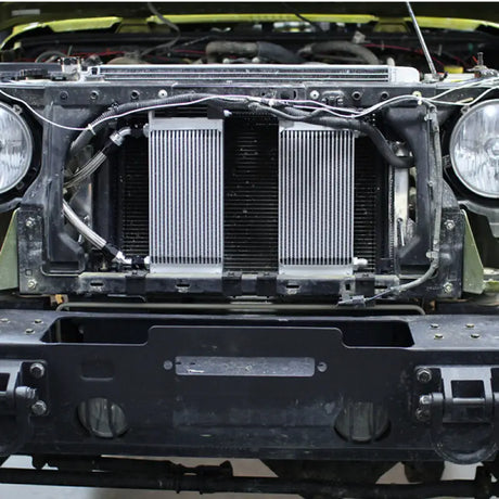 Front view of a vehicle with exposed radiator showing Mishimoto oil cooler kit for Jeep Wrangler