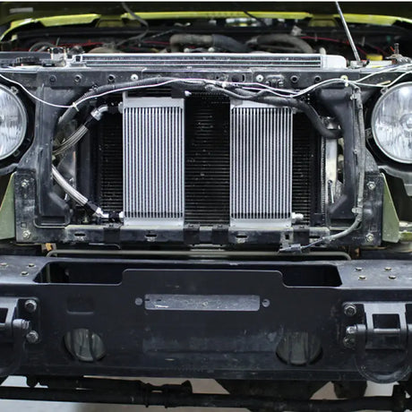 Front of Jeep Wrangler JK with exposed radiator showing Mishimoto oil cooler kit