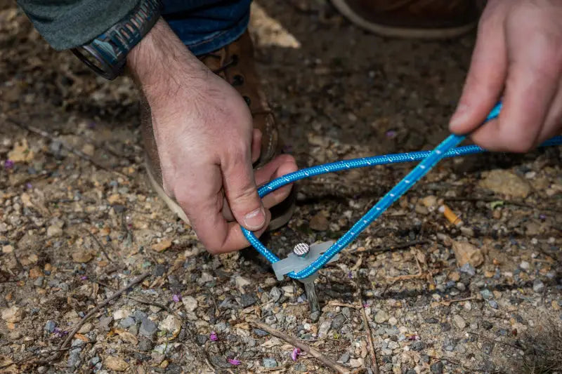 Blue rope attached to metal stake for Mishimoto Borne Rooftop Awning setup