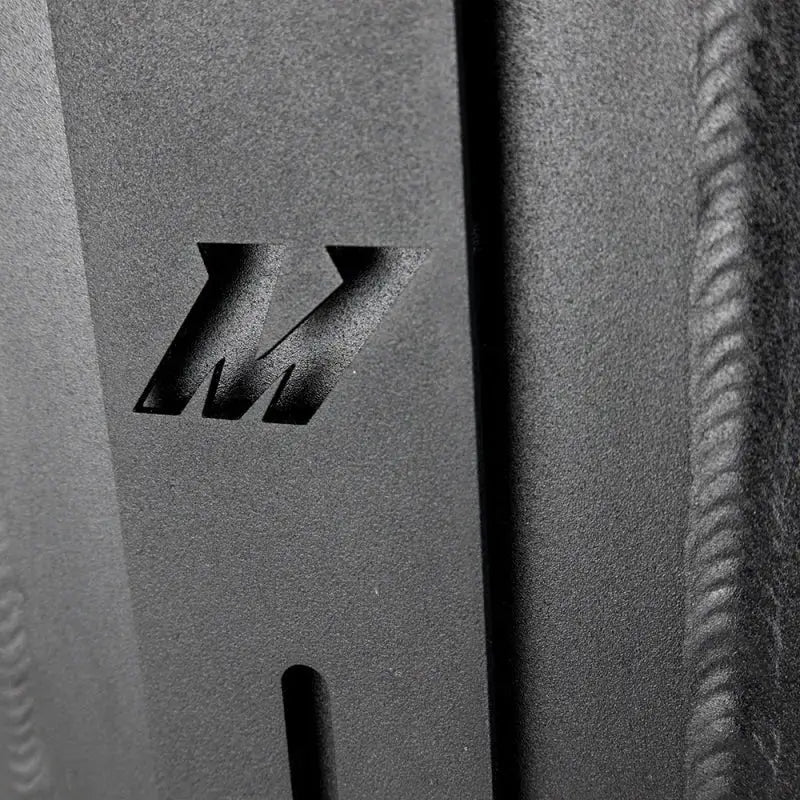 Textured metal with cut-out Mishimoto logo on dual pass intercooler dual side inlet/outlet