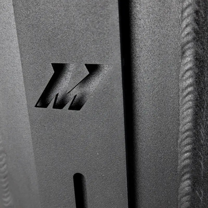 Black metal Mishimoto universal air-to-water intercooler cut-out logo plate image