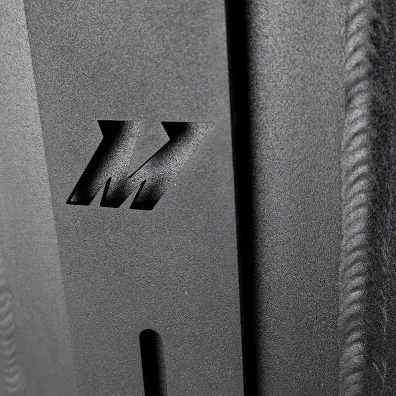 Textured metal with cut-out Mishimoto logo on dual pass intercooler dual side inlet/outlet