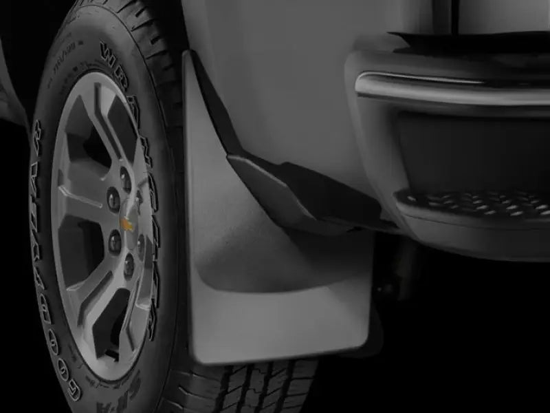Black thermoplastic direct-fit contoured mud flap set of 2 without logo featuring QuickTurn fastening system, mounted on the rear fender of a vehicle.