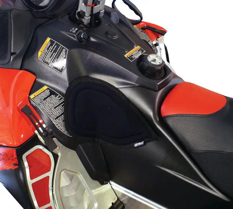 Black and red snowmobile seat with fuel cap, perfect for console knee pads and knee comfort