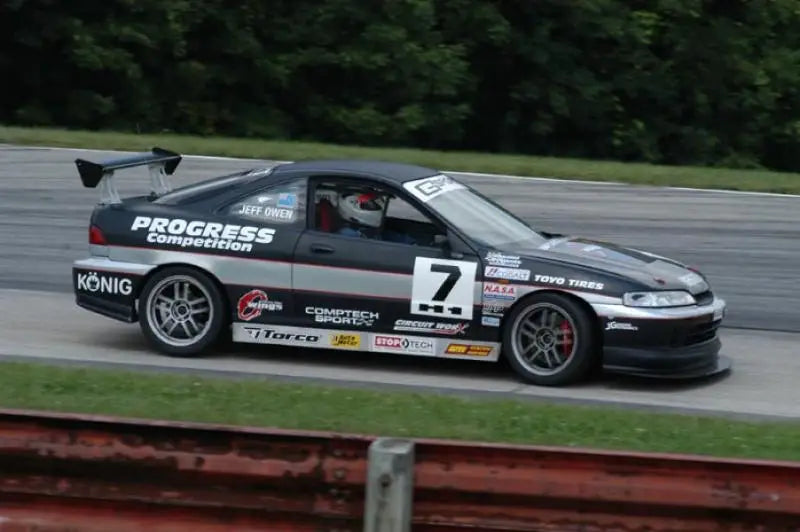 Black race car with spoiler on Progress Tech Acura Integra coil-over system 450lb RR