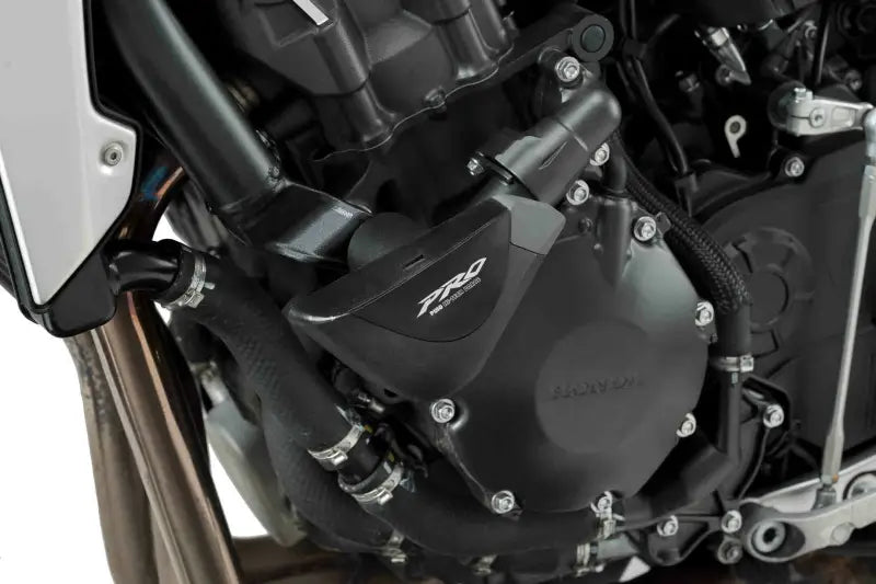 Black motorcycle engine with Puig 9754N frame sliders and visible hoses