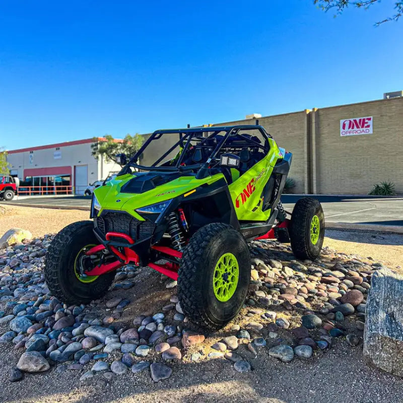 Lime green off-road vehicle with QuadBoss Polaris RZR tie rod assembly kit installed