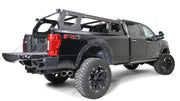 Fab Fours Adjustable Rack System (RACK01-01-1) mounted on a black FX4 truck, showcasing its sleek black and gray finish and ample cargo space.