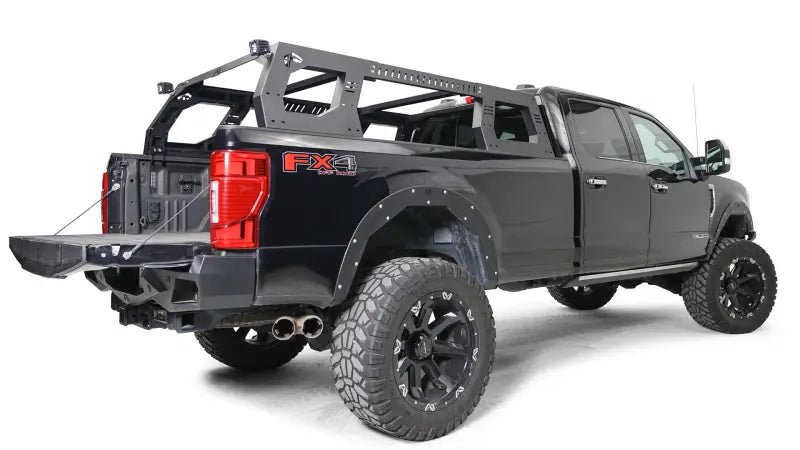 Fab Fours Adjustable Rack System (RACK01-01-1) mounted on a black FX4 truck, showcasing its sleek black and gray finish and ample cargo space.