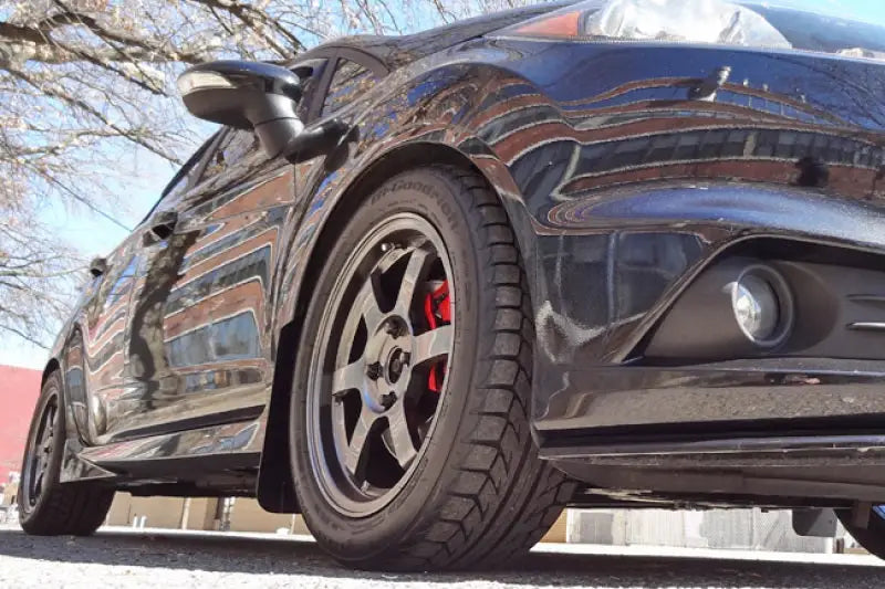 Ford Fiesta with rally armor black mud flap, aftermarket wheels, and red brake calipers