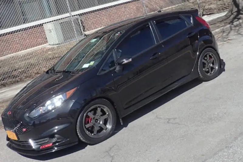 Black mud flap with Rally Armor logo on Ford Fiesta ST with aftermarket wheels and red calipers