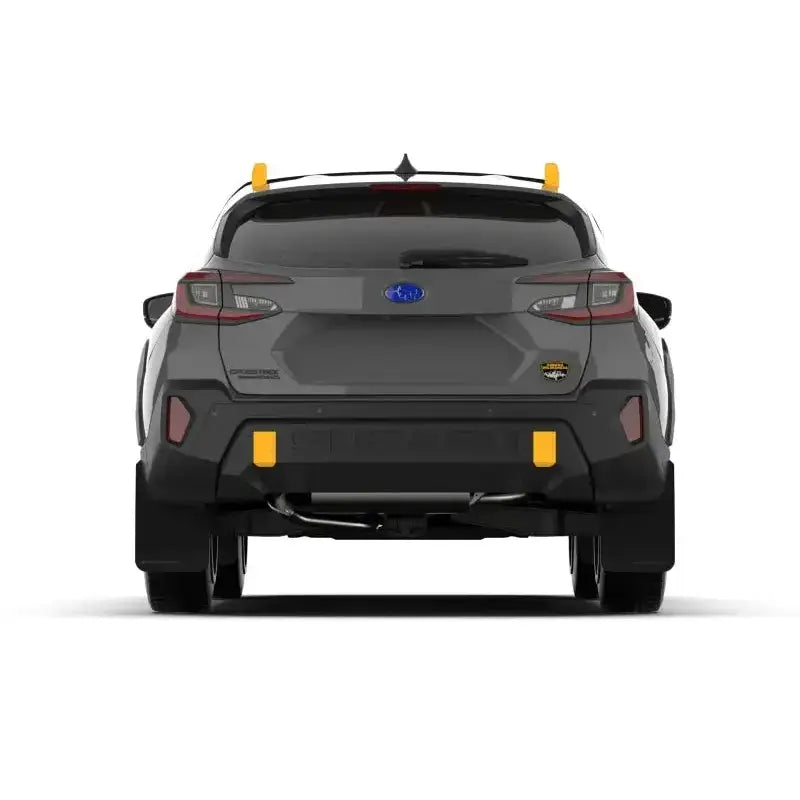 Rear view of a 2024 Subaru Crosstrek Wilderness with Rally Armor black UR mudflaps featuring a wild-orange logo, showcasing durable protection and no-drill installation.