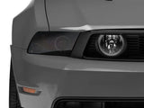 Gray car front with tinted headlight showcasing Raxiom LED Halo Fog Lights for Mustang