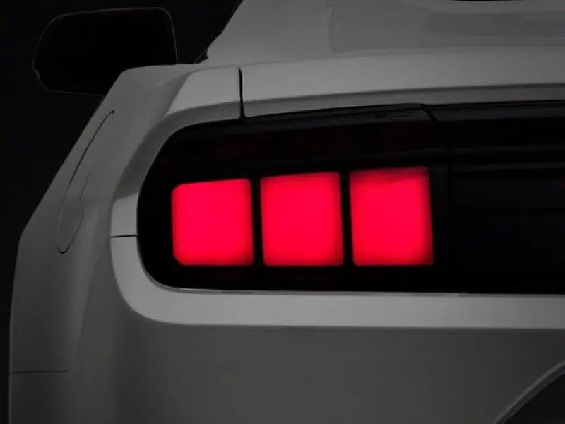 White Ford Mustang rear with smoked lens profile LED tail lights glowing red