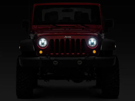 Red Jeep Wrangler with illuminated LED Daymaker headlights in chrome housing