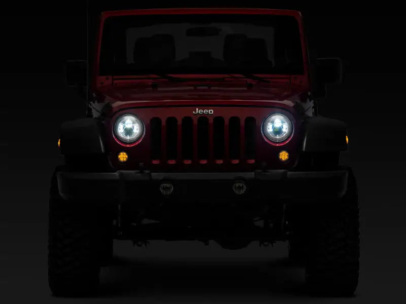 Red Jeep Wrangler with illuminated LED Daymaker headlights in chrome housing