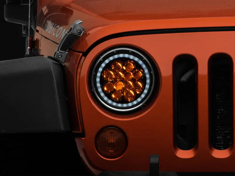 Orange Jeep Wrangler headlight featuring Axial Spider LED with amber DRL in chrome housing